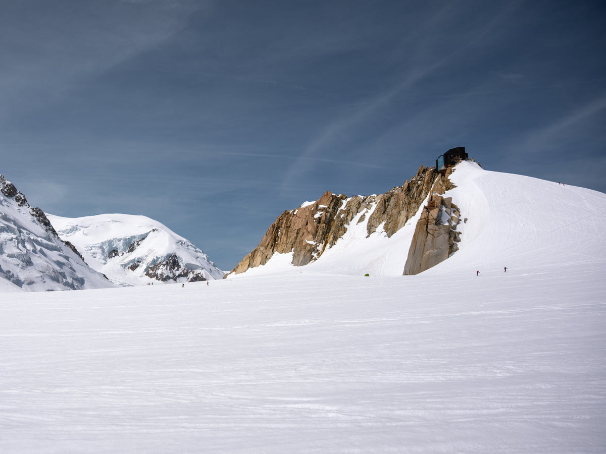 De la neige, des aiguilles rocheuses et un ciel strié.