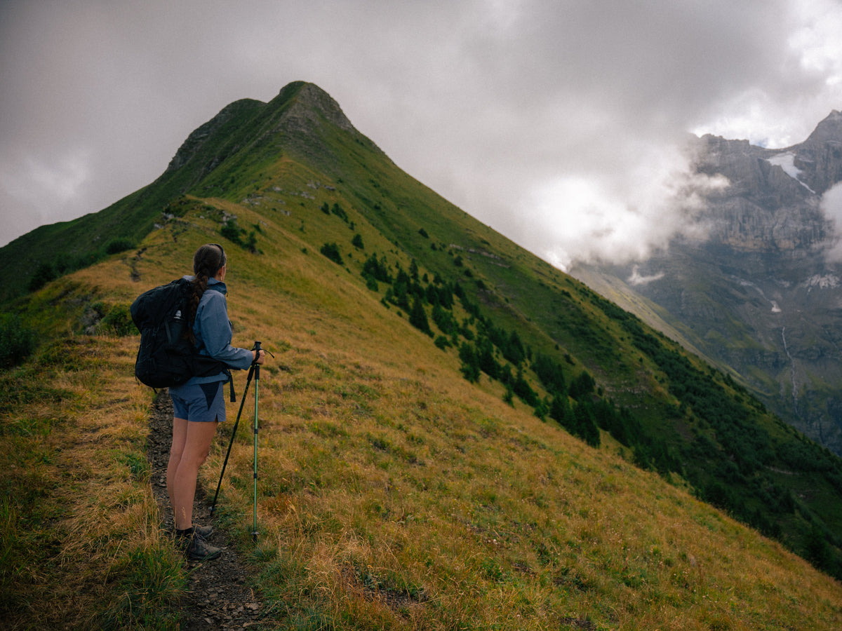 Une randonneuse sur la crête herbeuse de Chalin, au bord des nuages.