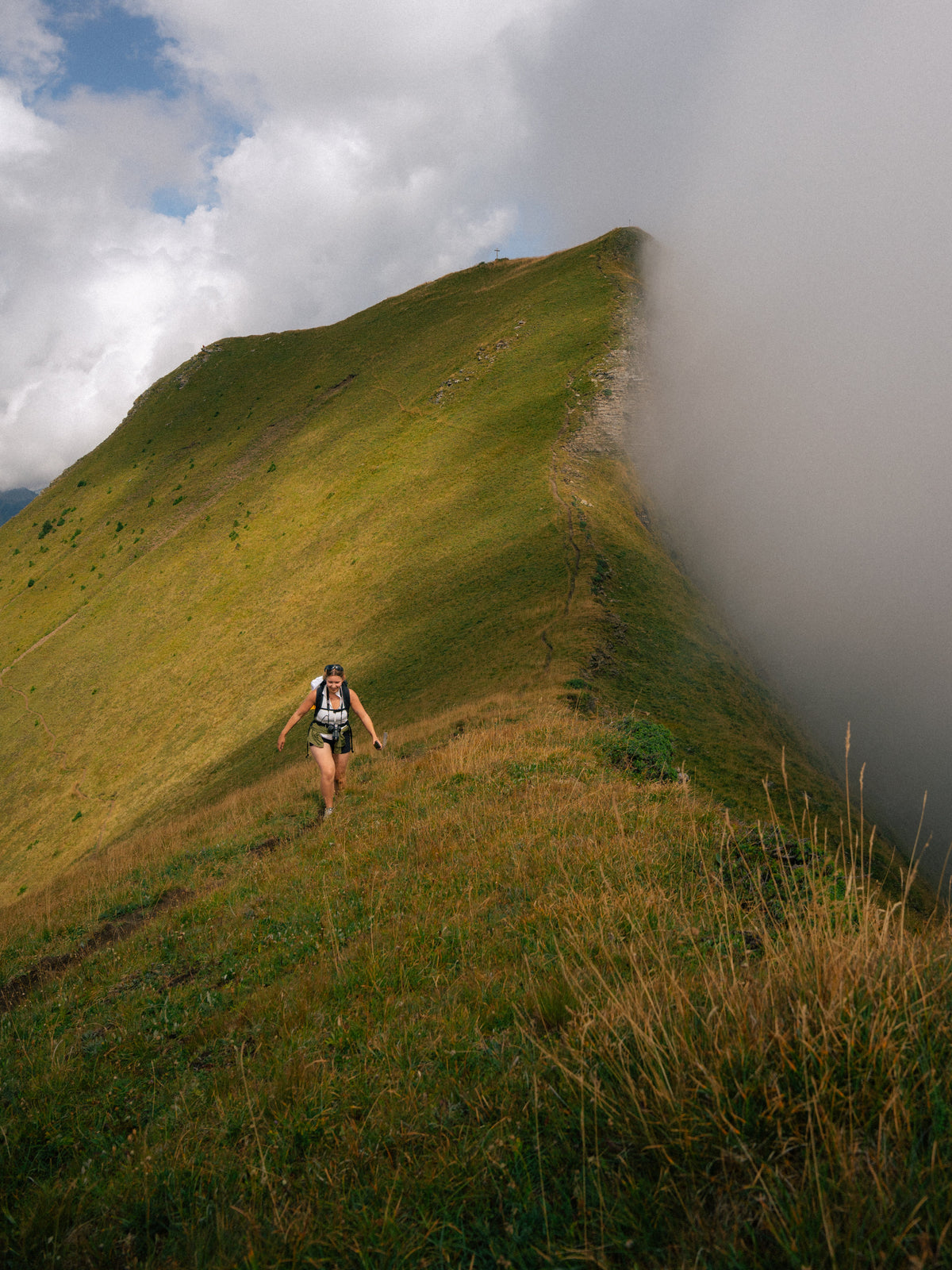 Une silhouette minuscule sur l’arête au bord des nuages.