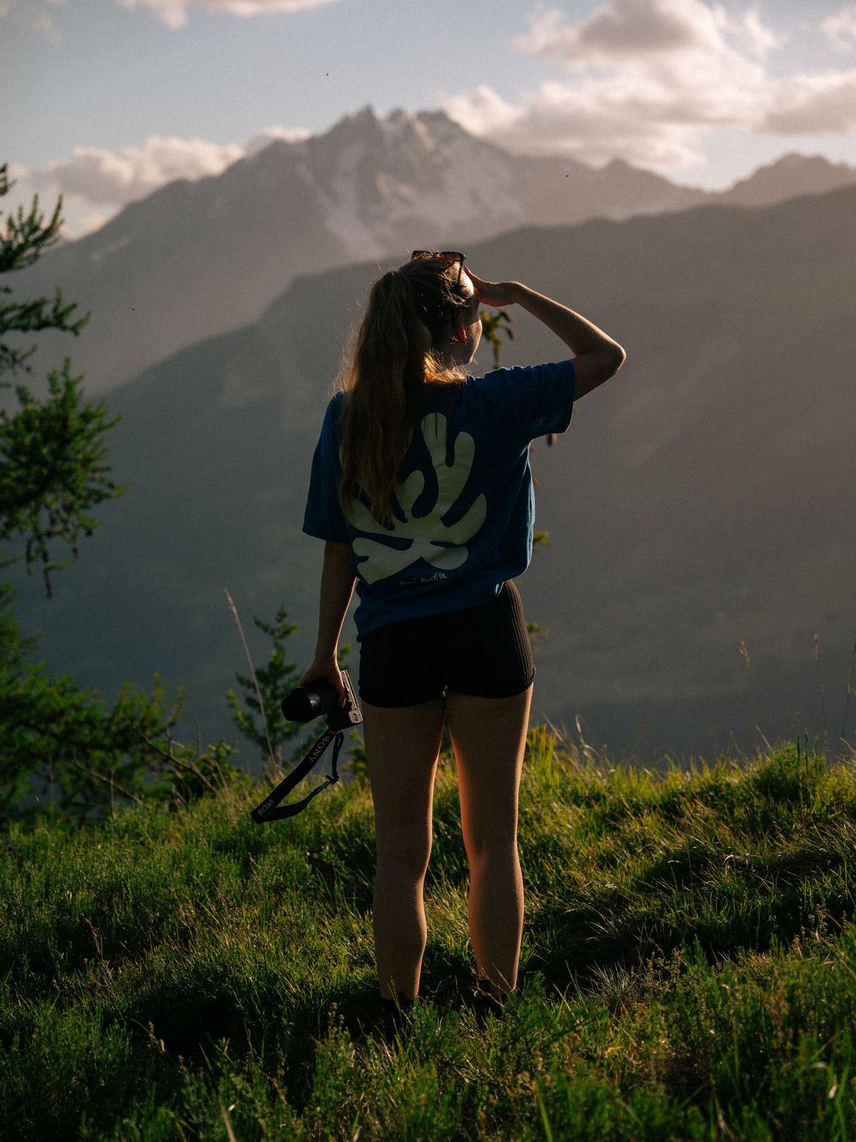 Rose se tient face aux montagnes enneigées.